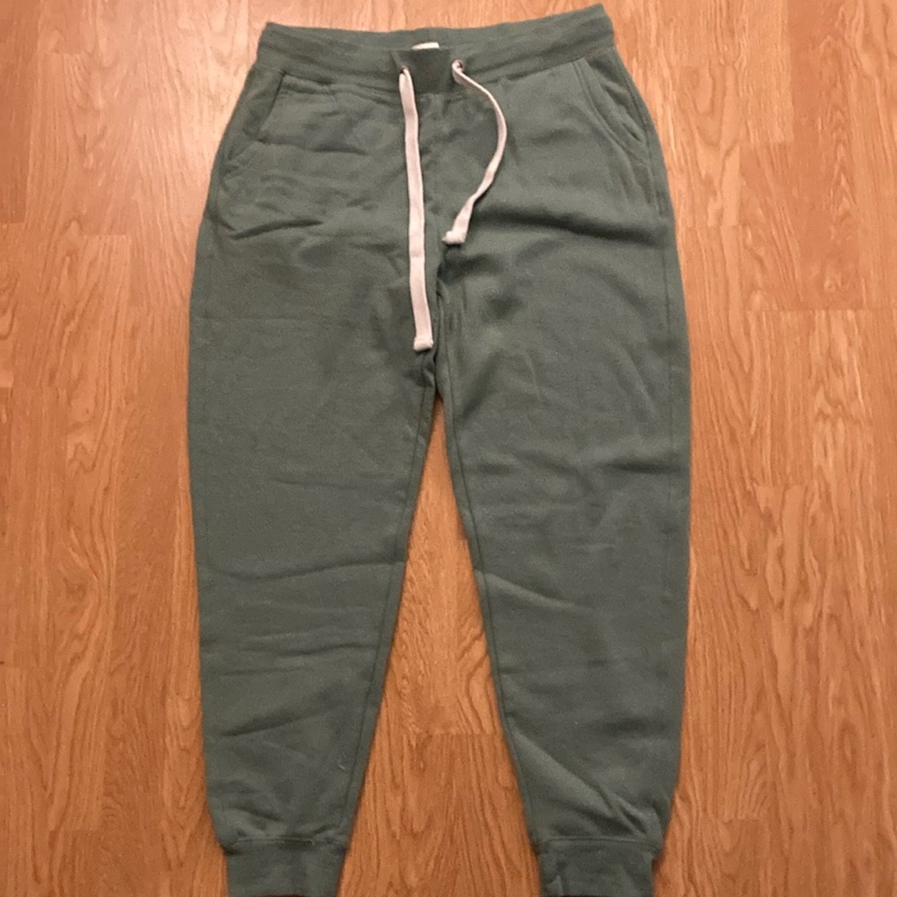 Green sweat pants with pockets on the back and white draw strings